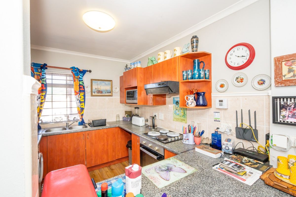 A functional kitchen featuring laminate cabinetry, granite countertops, a double bowl sink, and built-in cooking appliances with a tiled backsplash.