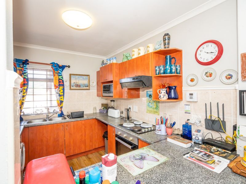 A functional kitchen featuring laminate cabinetry, granite countertops, a double bowl sink, and built-in cooking appliances with a tiled backsplash.