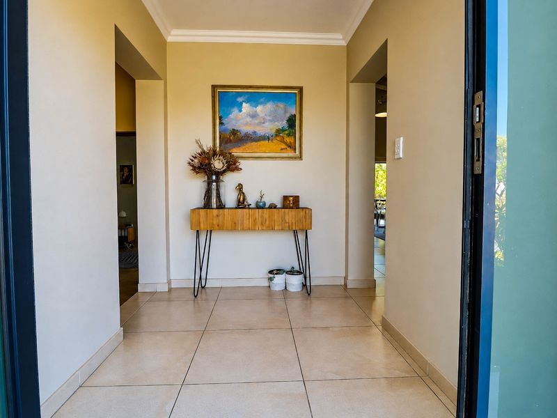 A bright and welcoming entrance hall featuring neutral tiled flooring and clean wall finishes, providing a clear transition into the home's living spaces.