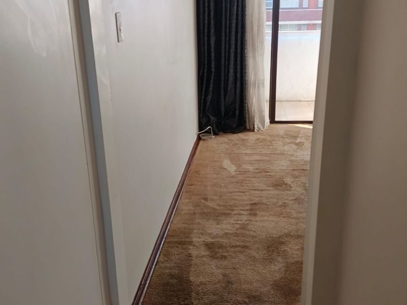 An empty bedroom featuring carpeted flooring and a sliding glass door providing access to an outdoor area.