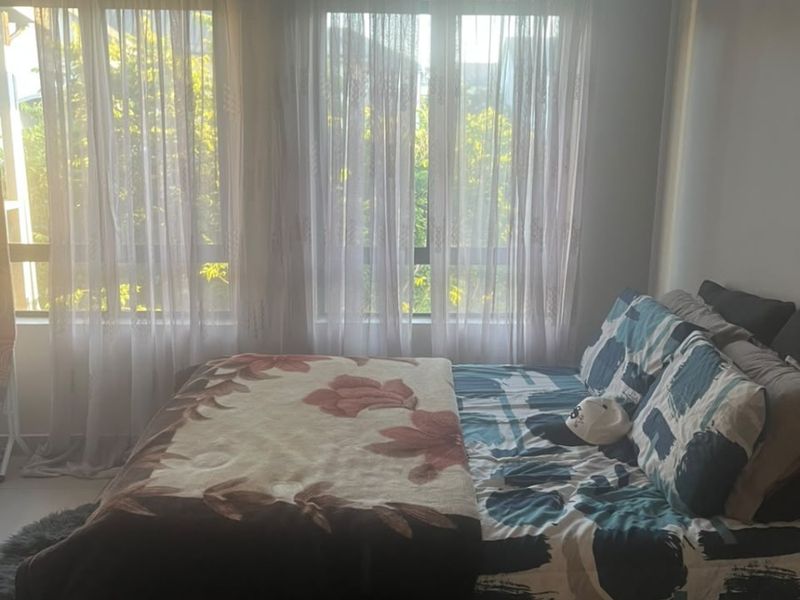 A bedroom featuring large windows that allow for natural light, finished with decorative cove cornicing.