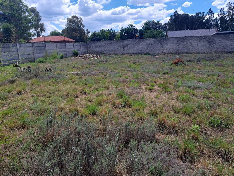 A vacant residential plot featuring a precast concrete boundary wall and installed electric fencing, ready for development.