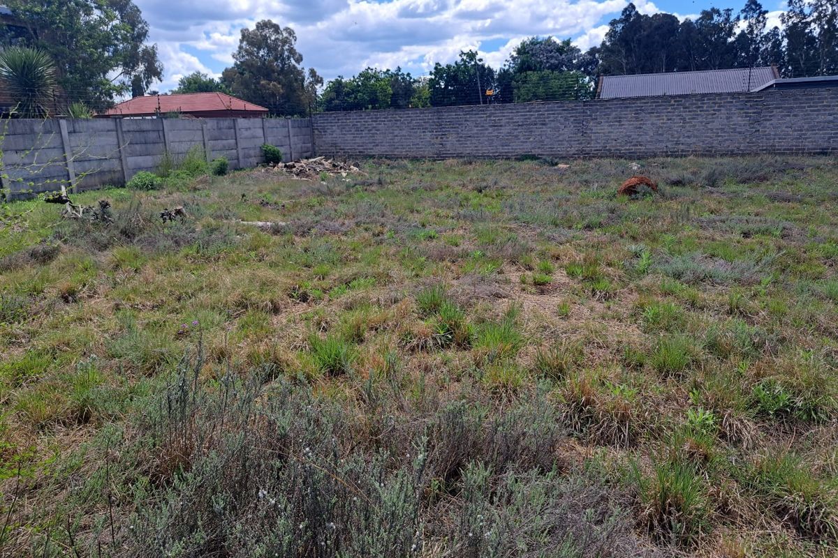 A vacant residential plot featuring a precast concrete boundary wall and installed electric fencing, ready for development.