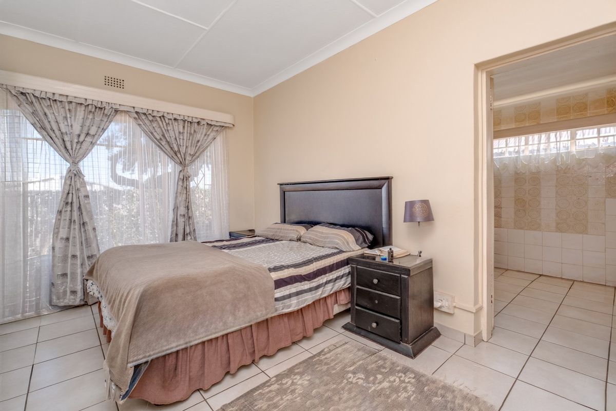 A bedroom featuring tiled flooring, coved ceilings, and direct access to an en-suite bathroom.
