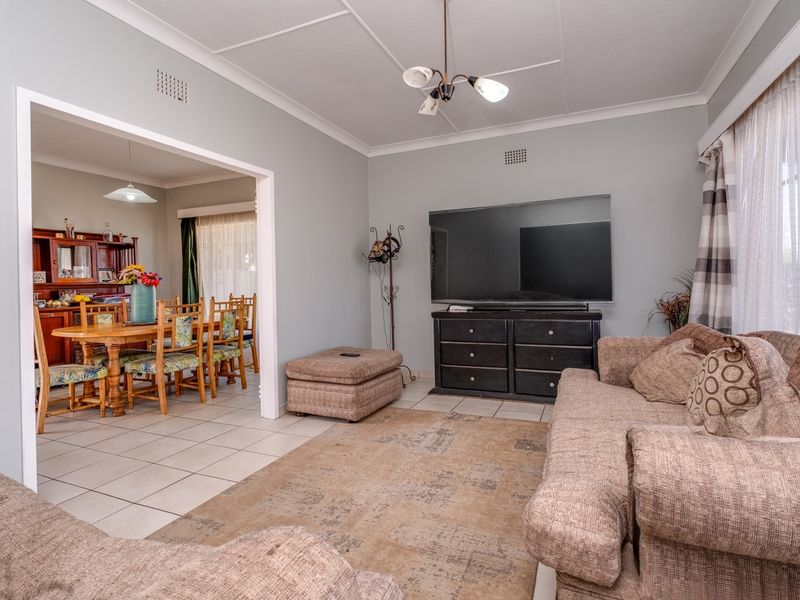 Open plan living and dining area featuring tiled flooring, coved cornicing, and neutral wall tones, providing a functional and connected living space.