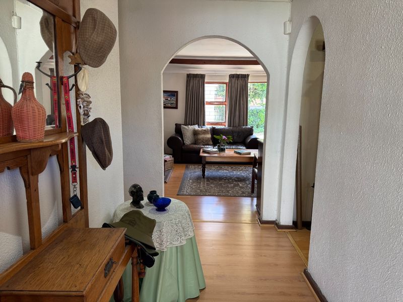 An inviting entryway featuring arched doorways and laminate flooring, providing a clear view into the adjacent living area.