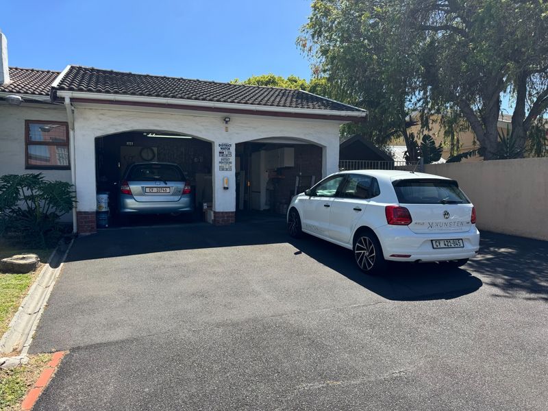 A double garage with a tiled roof and an asphalt driveway, providing secure off-street parking.
