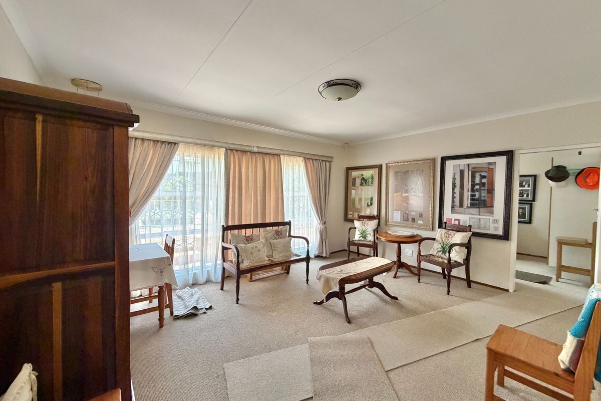 A spacious living room featuring neutral carpeting and large sliding glass doors that provide ample natural light.