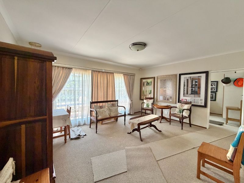 A spacious living room featuring neutral carpeting and large sliding glass doors that provide ample natural light.