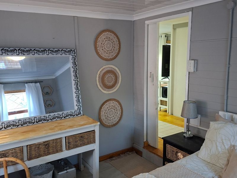 A bedroom featuring timber wall paneling and a sliding door leading to an adjacent room.