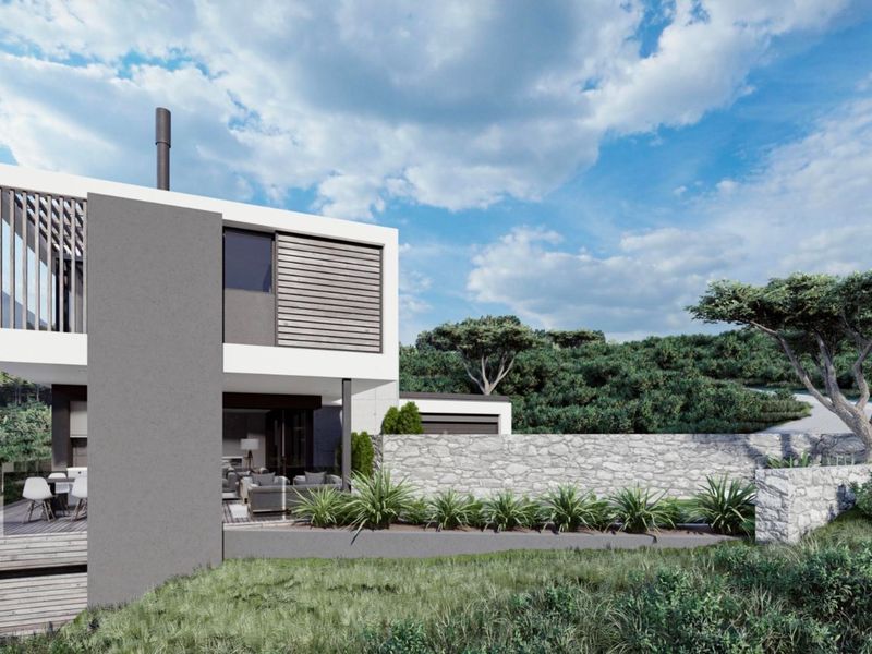 Modern architectural rear elevation featuring timber decking, glass balustrades, and a natural stone retaining wall set against a landscaped hillside.