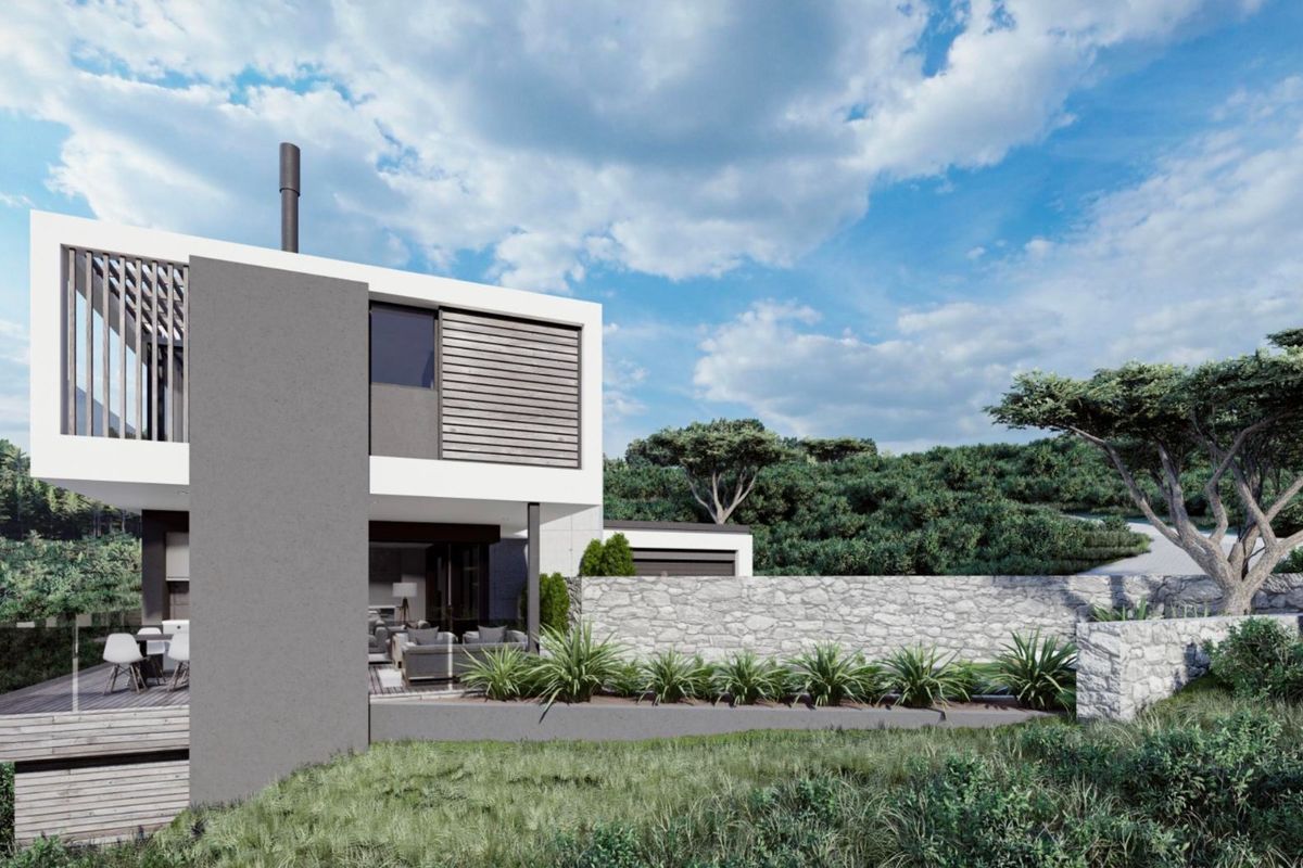 Modern architectural rear elevation featuring timber decking, glass balustrades, and a natural stone retaining wall set against a landscaped hillside.