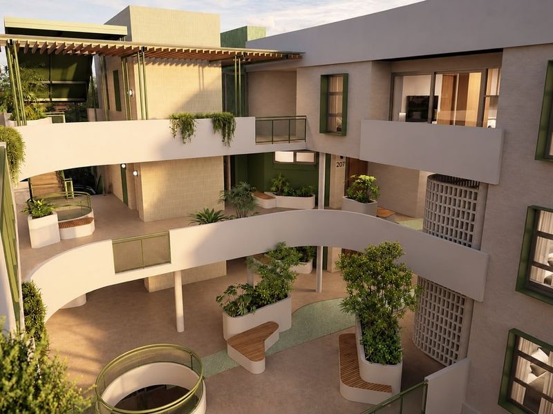 A modern apartment complex courtyard featuring multi-level walkways, integrated planters, built-in seating, and architectural breeze block detailing.