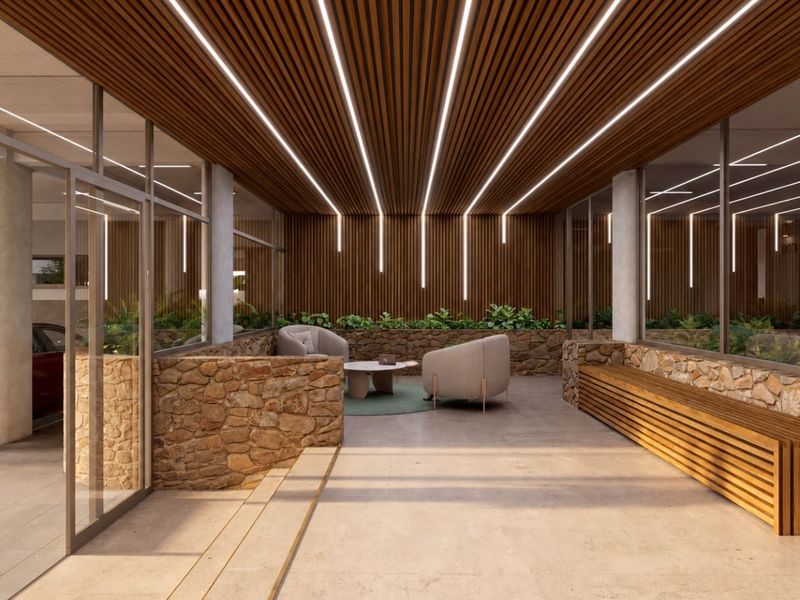 Modern entrance lobby featuring a slatted timber ceiling with integrated linear lighting, stone wall accents, and a built-in timber bench.