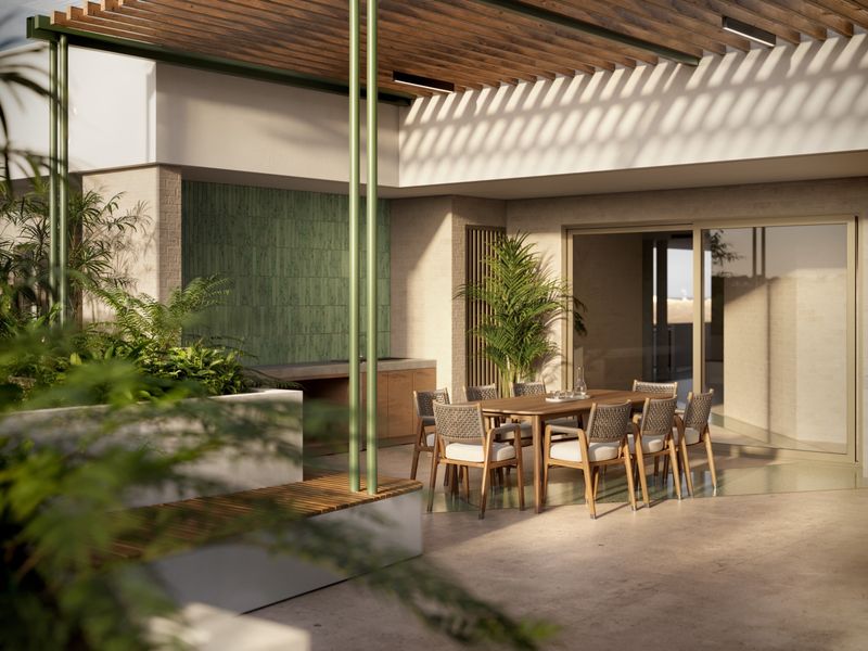 A modern covered patio featuring a timber pergola, built-in outdoor kitchen, and seamless access to the interior through large sliding glass doors.