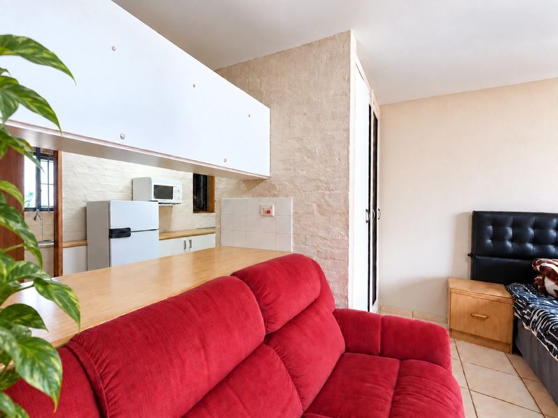 Open plan living area featuring a kitchen pass-through counter, tiled flooring, and built-in storage cupboards.