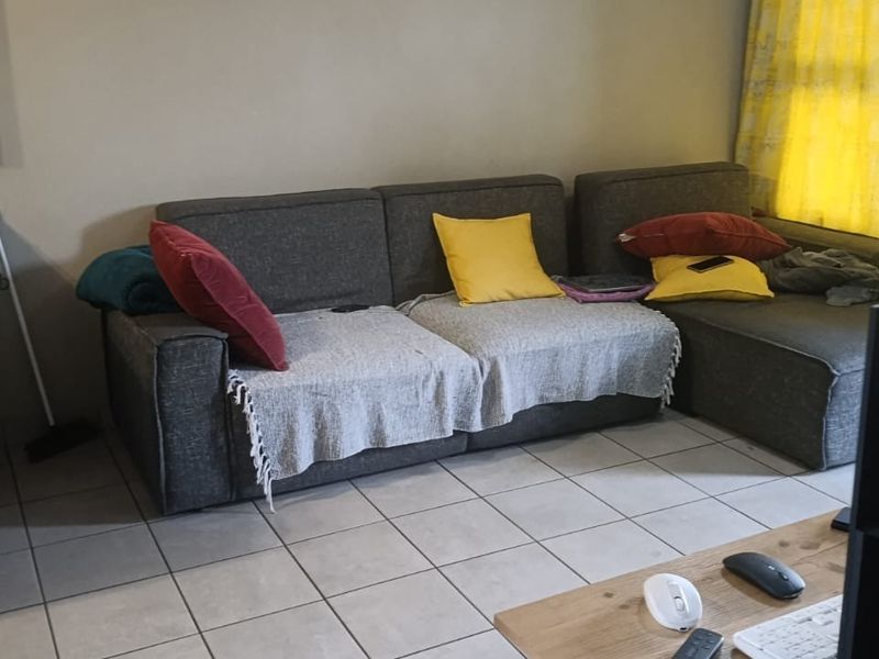 Open plan living area featuring tiled flooring and a compact kitchen section with granite countertops.