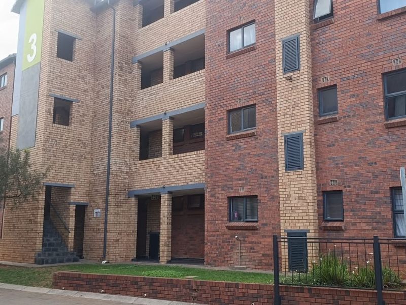 A multi-story apartment building featuring a face brick facade, aluminum window frames, and integrated balcony spaces.