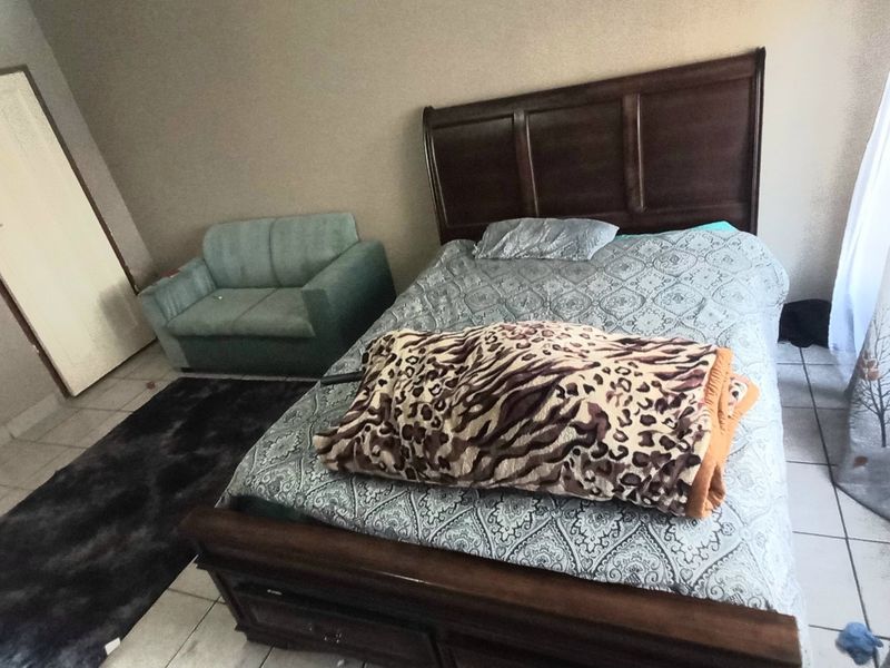 A bedroom featuring tiled flooring and two internal doors, providing a functional space with neutral wall finishes.