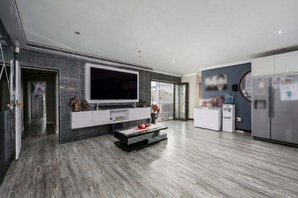 Spacious living area featuring modern laminate flooring, recessed lighting, and a custom built-in media console with integrated storage.