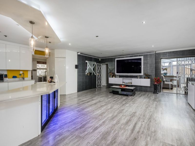 Spacious open-plan living area featuring a modern kitchen with quartz island, built-in wine cooler, and contemporary finishes throughout.