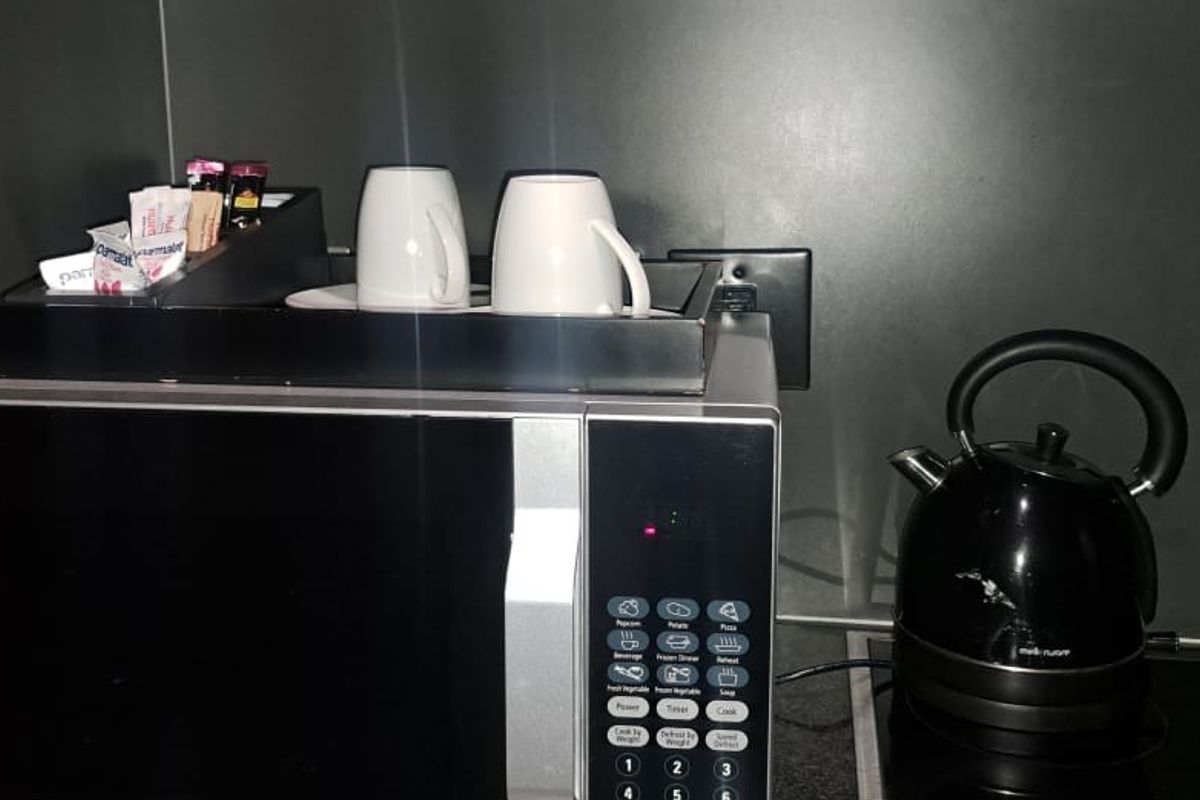 A compact kitchen preparation area featuring a built-in microwave and an electric hob.