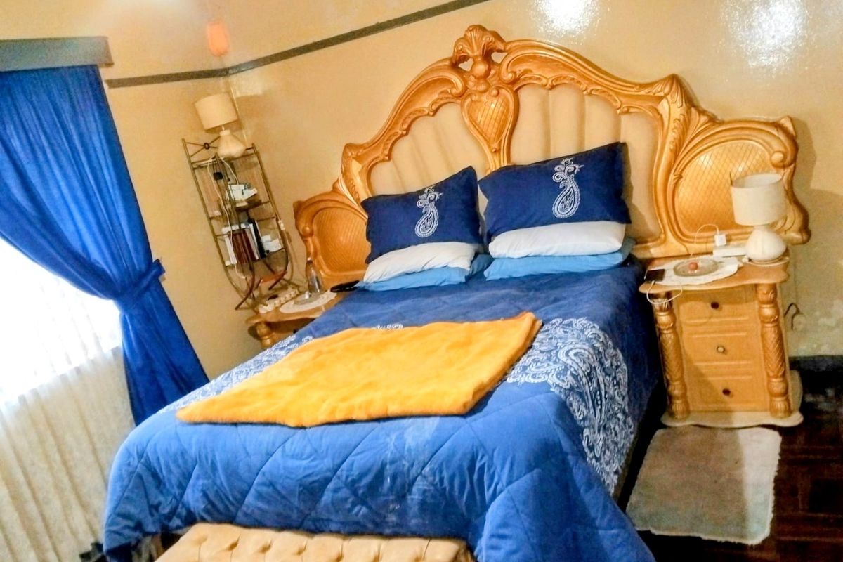 A bedroom featuring parquet flooring and a picture rail, presented in a dated style.