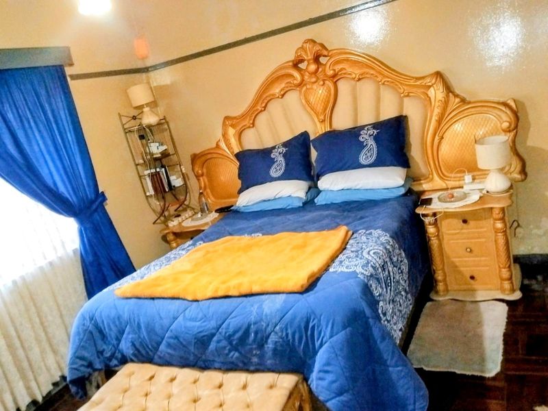 A bedroom featuring parquet flooring and a picture rail, presented in a dated style.