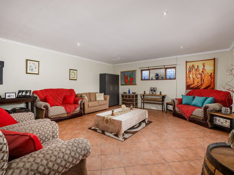 Spacious living room featuring neutral walls, ceramic tile flooring, and recessed downlighting, offering a comfortable and well-maintained area for relaxation.
