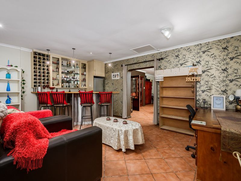 A dedicated bar area featuring a built-in counter, integrated wine storage, and tiled flooring, providing a functional space for entertaining.