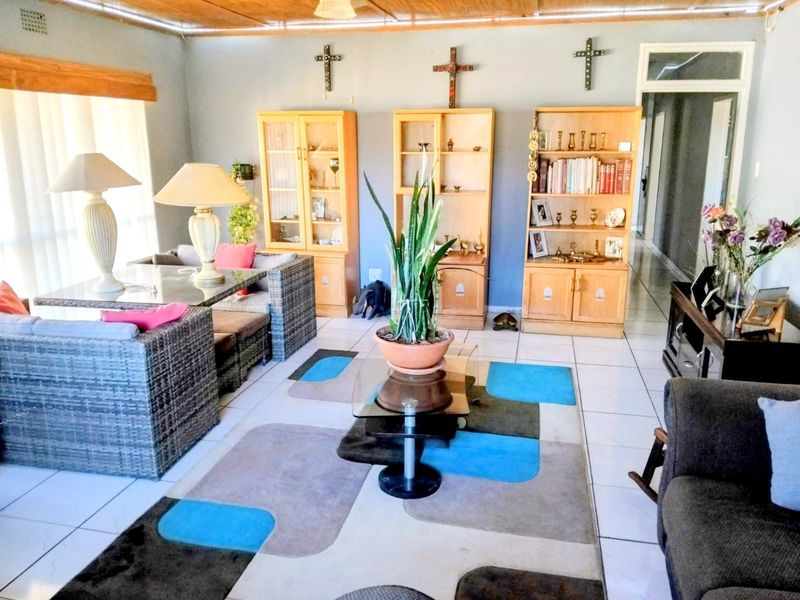 Spacious living area featuring tiled flooring, timber ceiling, and built-in wooden cabinetry, offering a functional layout for relaxation and storage.
