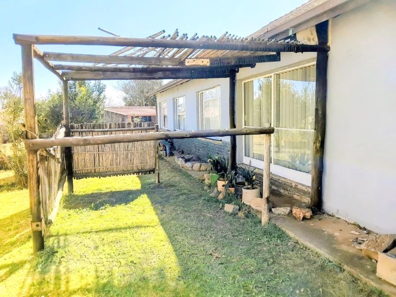 Outdoor patio area featuring a timber pergola structure and sliding glass door access to the main house.