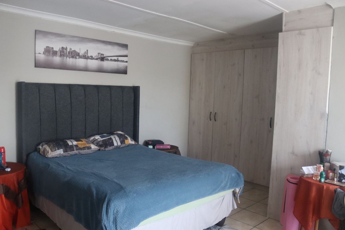 A bedroom featuring built-in cupboards, tiled flooring, and a coved ceiling.