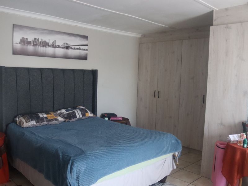 A bedroom featuring built-in cupboards, tiled flooring, and a coved ceiling.