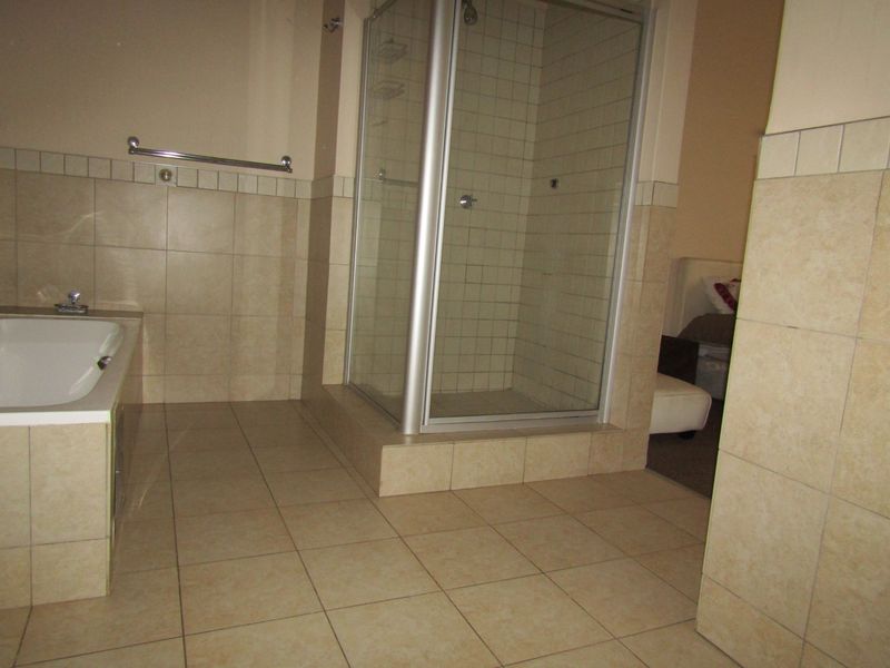 Bathroom featuring a built-in bathtub and a separate shower enclosure with tiled walls and flooring.