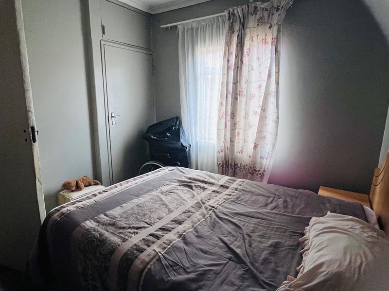A standard bedroom featuring a built-in cupboard and natural light from the window.
