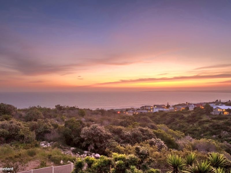 A scenic coastal sunset view overlooking the surrounding landscape and residential area.