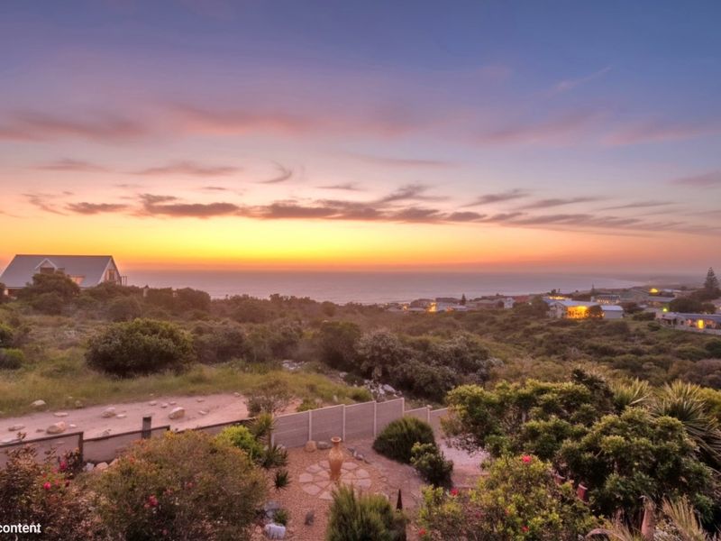 A scenic elevated view overlooking the coastal landscape and surrounding residential area at sunset.