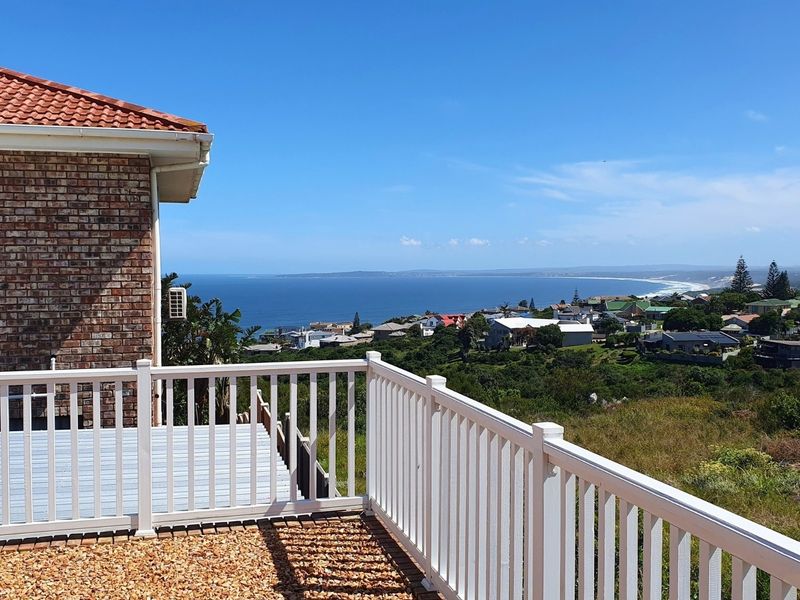 Elevated outdoor deck featuring a white balustrade with expansive coastal and ocean views.