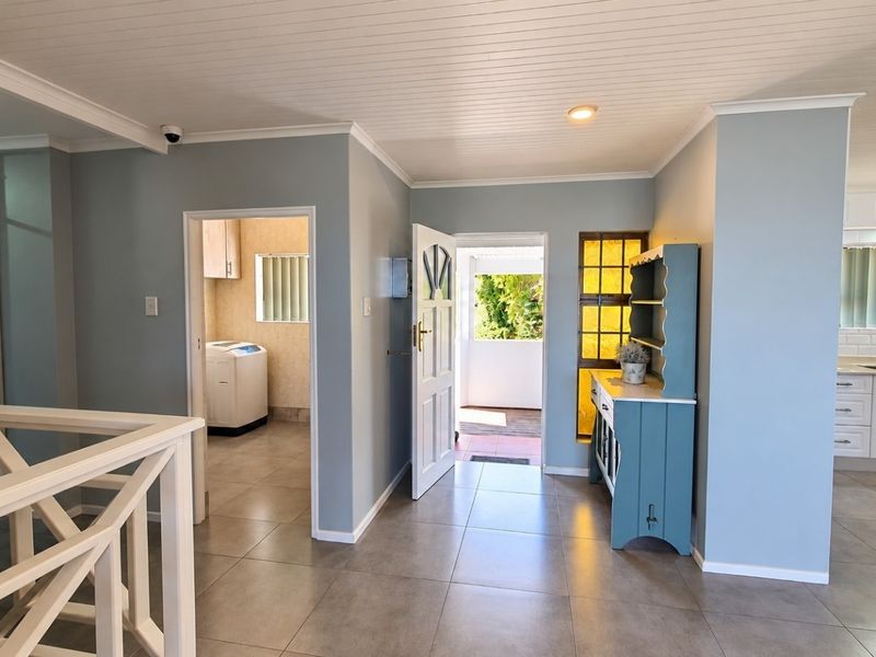 Open plan living area featuring tiled floors, tongue and groove ceilings, and seamless flow to the kitchen and laundry area.