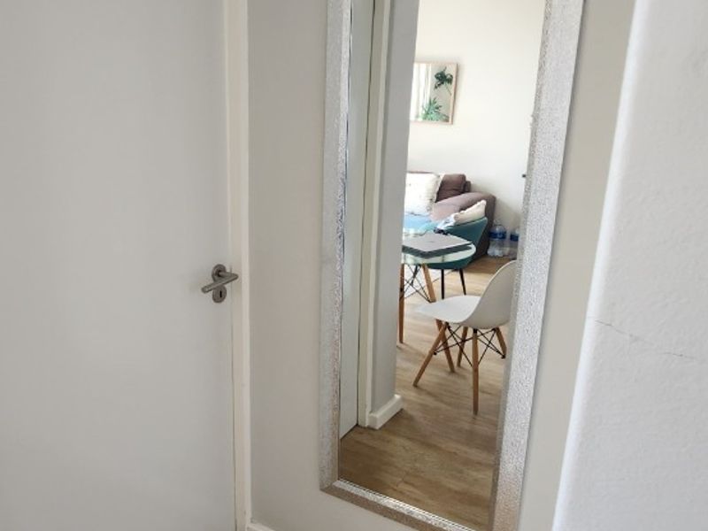 A clean and bright hallway featuring light-toned laminate flooring and a neutral wall finish, providing a seamless transition between living spaces.