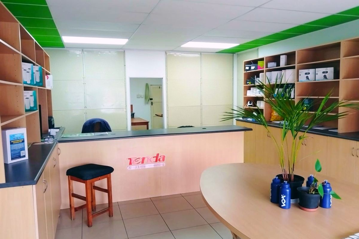 A retail service area featuring built-in cabinetry, a reception counter, drop ceiling with recessed lighting, and tiled flooring.