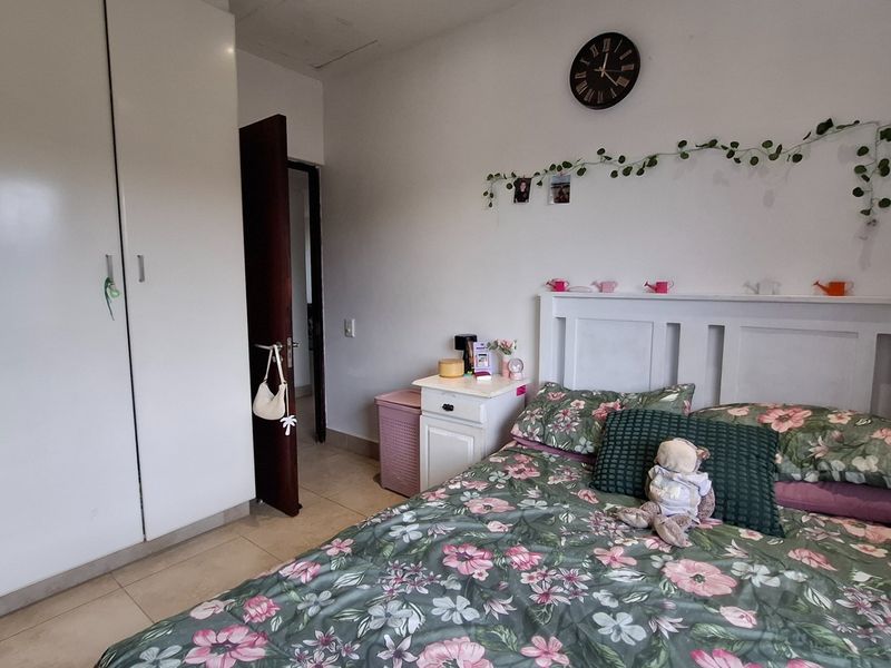A functional bedroom featuring built-in cupboards and tiled flooring, providing a practical living space.