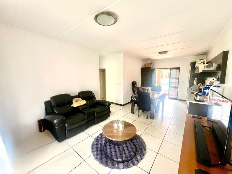 Open plan living and dining area featuring tiled flooring and direct access to an outdoor space through a sliding door.