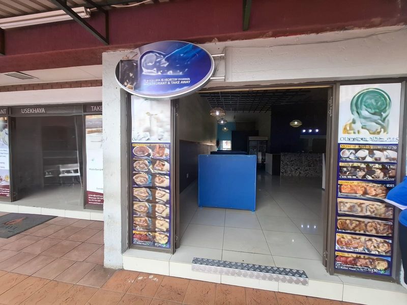 Commercial storefront entrance featuring glass doors, tiled flooring, and prominent signage, suitable for a restaurant or takeaway business.