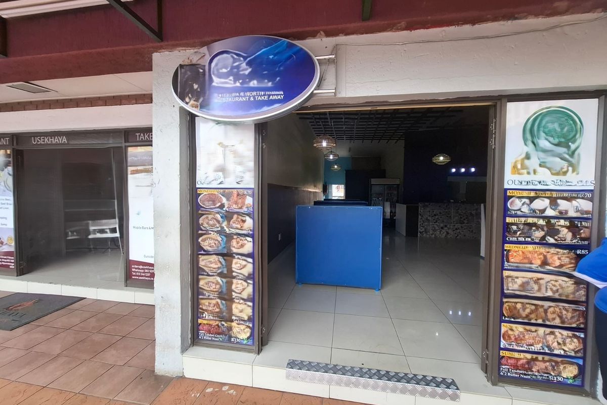 Commercial storefront entrance featuring glass doors, tiled flooring, and prominent signage, suitable for a restaurant or takeaway business.