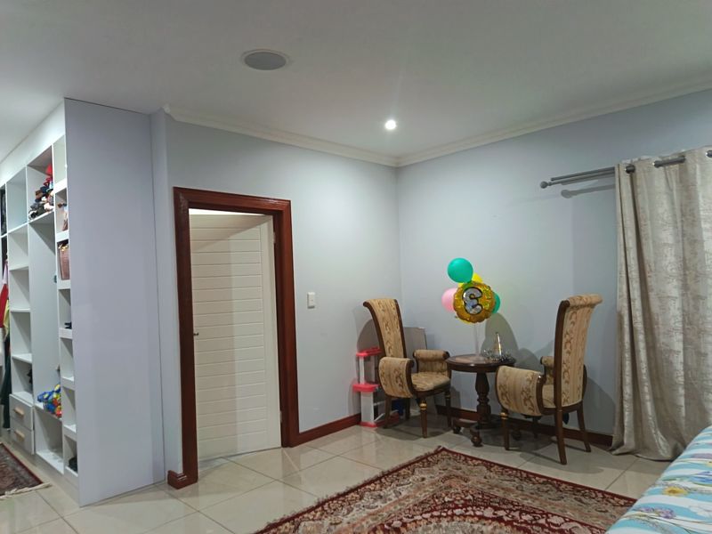 A bedroom featuring tiled flooring, recessed ceiling lighting, and a large built-in shelving unit with ample storage space.