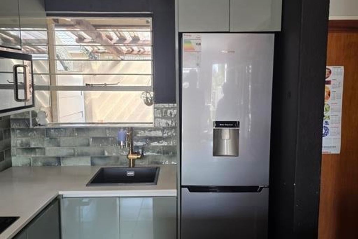 Modern kitchen featuring sleek cabinetry, stone countertops, a stylish tiled backsplash, and integrated appliances, offering a clean and functional culinary space.