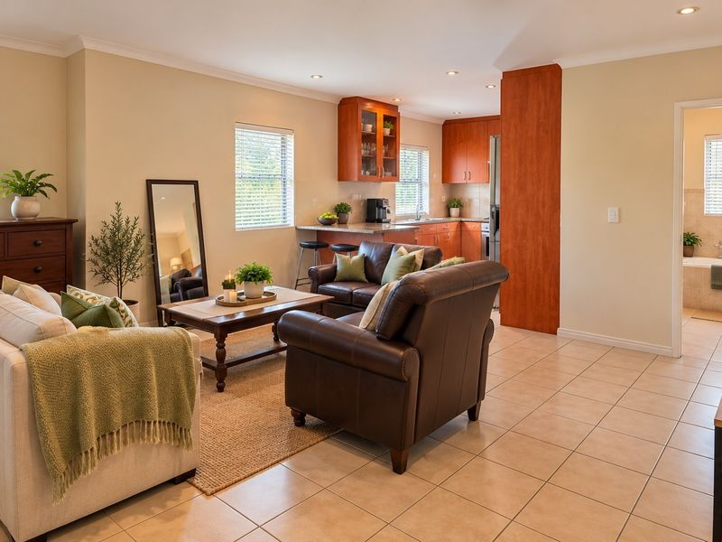 Spacious open-plan living area featuring tiled flooring, recessed lighting, and a functional kitchen with breakfast bar, seamlessly connecting to the adjacent bathroom.