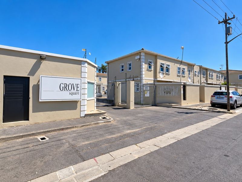 Street view of the Grove Square apartment complex entrance, featuring secure perimeter walls, electric fencing, and gated access.